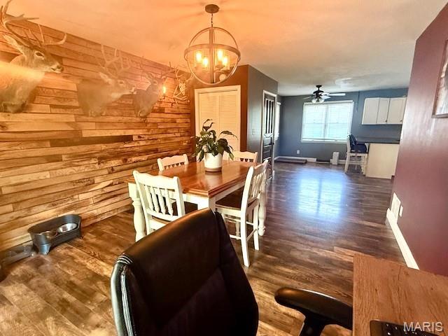902 Sycamore St, Germantown, IL 62245 - dining area with a chandelier, a ceiling fan, wood finished floors, and wood walls