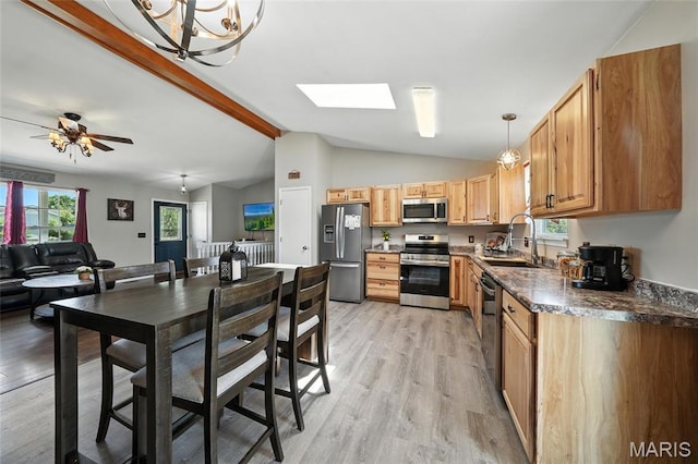 31 Kings Way Dr, Troy, MO 63379 - kitchen featuring appliances with stainless steel finishes, light wood finished floors, dark countertops, pendant lighting, and a skylight