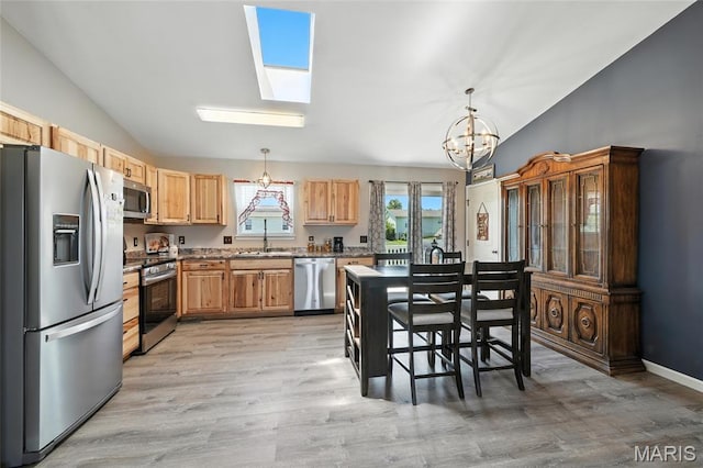 31 Kings Way Dr, Troy, MO 63379 - kitchen with appliances with stainless steel finishes, vaulted ceiling, a chandelier, light wood-style floors, and a skylight
