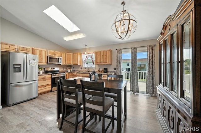 31 Kings Way Dr, Troy, MO 63379 - kitchen with stainless steel appliances, light brown cabinets, lofted ceiling, a chandelier, and a skylight