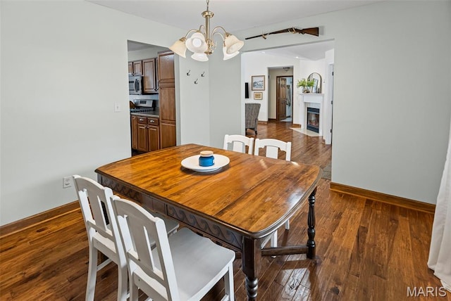 227 W Woodland Rdg, Valmeyer, IL 62295 - dining space featuring a chandelier, wood-type flooring, and a fireplace with flush hearth