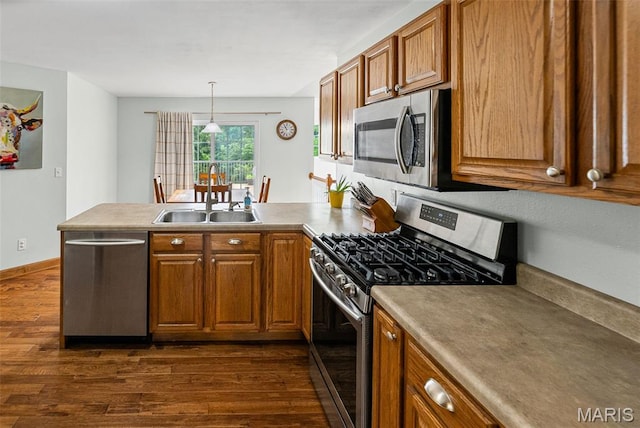 227 W Woodland Rdg, Valmeyer, IL 62295 - kitchen featuring stainless steel appliances, a peninsula, dark wood-style flooring, brown cabinets, and decorative light fixtures