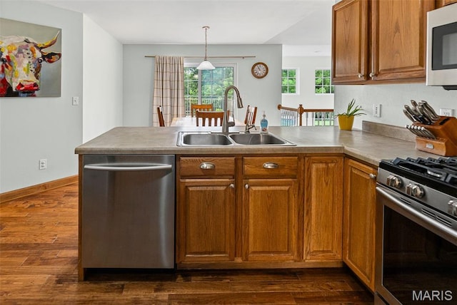 227 W Woodland Rdg, Valmeyer, IL 62295 - kitchen with stainless steel appliances, a peninsula, brown cabinetry, and dark wood-style flooring
