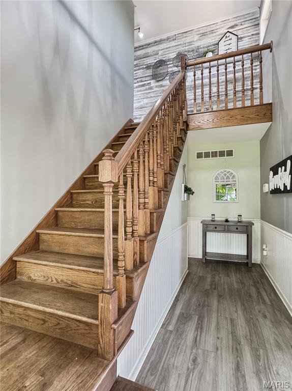 360 David Dr, Washington, MO 63090 - stairway featuring a towering ceiling, wood finished floors, and a wainscoted wall