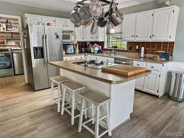360 David Dr, Washington, MO 63090 - kitchen with appliances with stainless steel finishes, washer / clothes dryer, white cabinets, and light wood finished floors