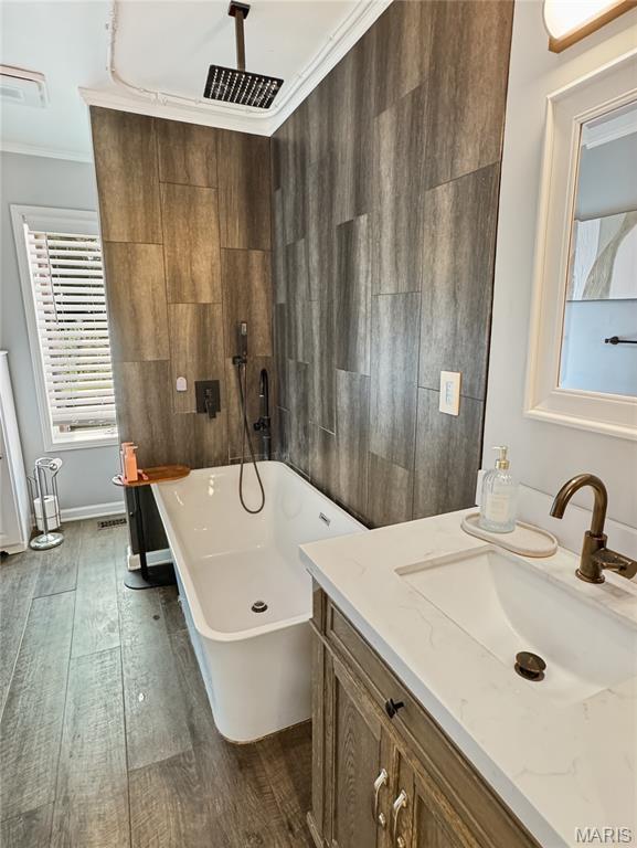 360 David Dr, Washington, MO 63090 - bathroom with a soaking tub, wood finished floors, ornamental molding, and vanity