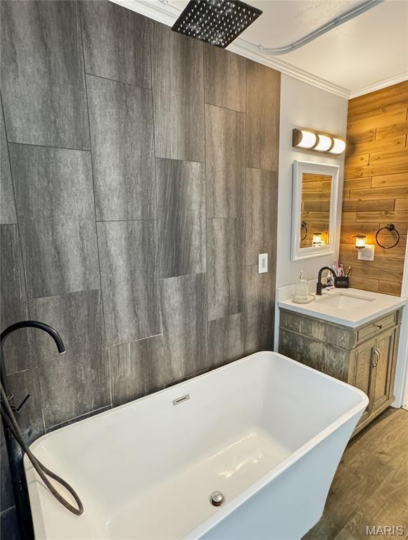 360 David Dr, Washington, MO 63090 - full bathroom featuring wood finished floors, a freestanding tub, ornamental molding, vanity, and wood walls