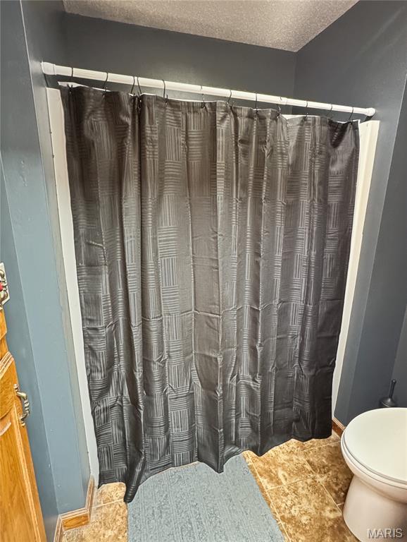 360 David Dr, Washington, MO 63090 - bathroom with a shower with shower curtain and a textured ceiling