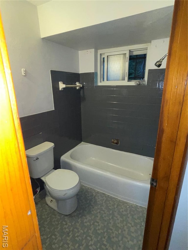2010-12 E Desoto Ave, Saint Louis, MO 63107 - full bathroom featuring tile walls, a bath, tile patterned floors, and a wainscoted wall