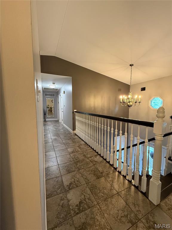 10755 Kennerly Rd, Sunset Hills, MO 63128 - corridor featuring a chandelier, an upstairs landing, tile patterned flooring, and vaulted ceiling