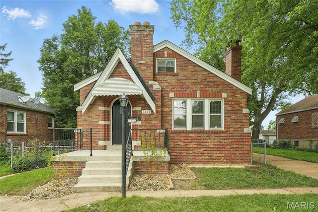 8609 Engler Ave, Saint Louis, MO 63114 - tudor house featuring a chimney and brick siding