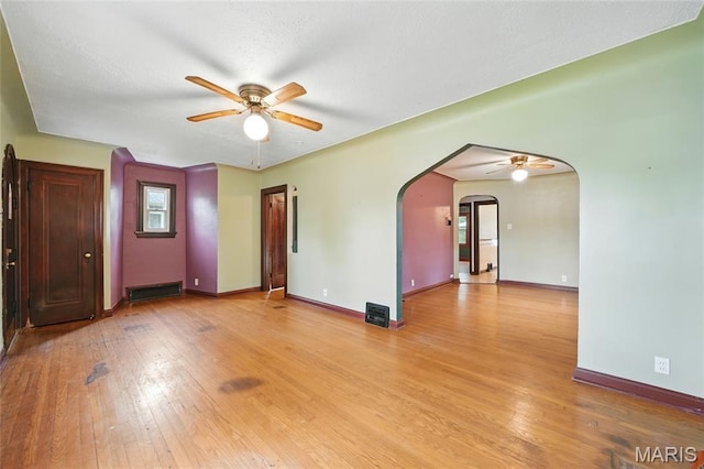 8609 Engler Ave, Saint Louis, MO 63114 - empty room with ceiling fan, arched walkways, and hardwood / wood-style floors