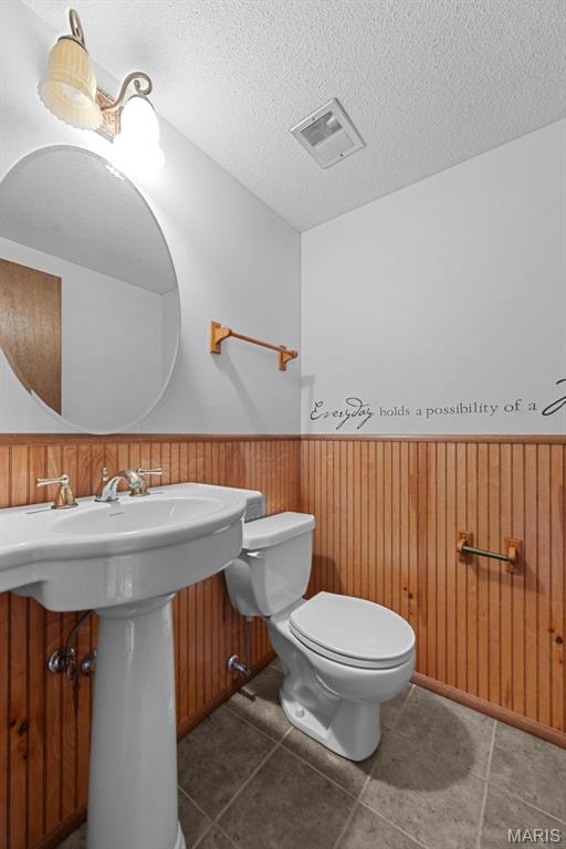 11894 Featherwood Dr, Creve Coeur Township, MO 63146 - bathroom with a wainscoted wall, a textured ceiling, and tile patterned flooring
