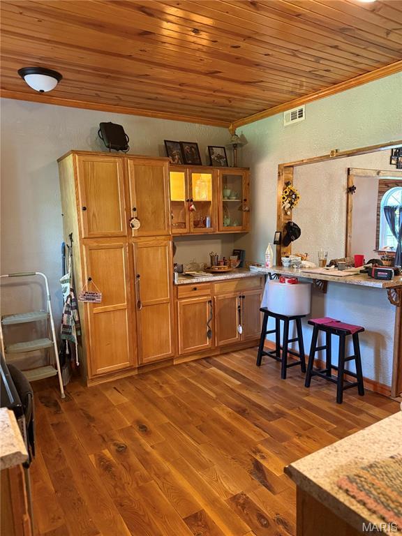 32 E 4th St, Gerald, MO 63037 - kitchen featuring wooden ceiling, a textured wall, brown cabinetry, wood finished floors, and crown molding