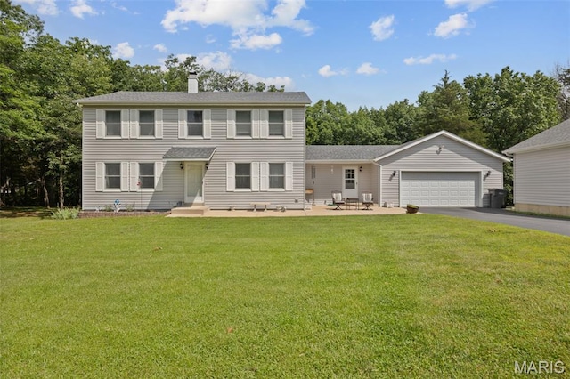 6235 Meadowlark Ln, Troy, MO 63379 - colonial inspired home featuring driveway, a garage, a front lawn, a chimney, and view of wooded area