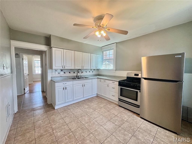 6328 Bradley Ave, Saint Louis, MO 63139 - kitchen featuring appliances with stainless steel finishes, light countertops, healthy amount of natural light, and white cabinets