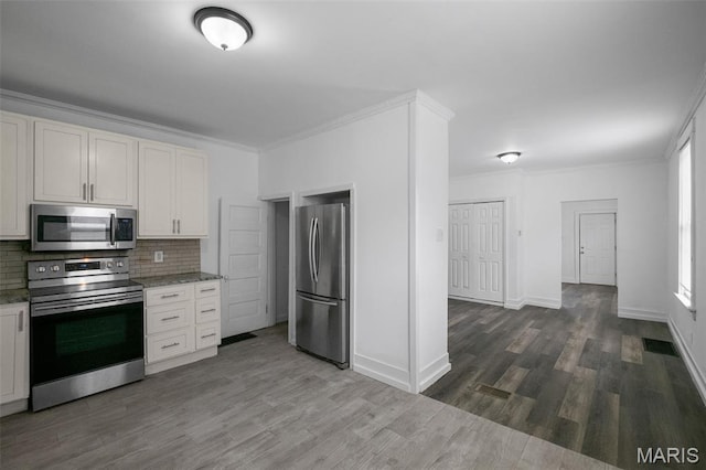 4340 Gannett St, Saint Louis, MO 63116 - kitchen featuring appliances with stainless steel finishes, tasteful backsplash, dark wood finished floors, ornamental molding, and light stone countertops