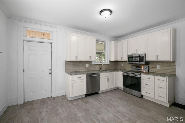 4340 Gannett St, Saint Louis, MO 63116 - kitchen with appliances with stainless steel finishes, tasteful backsplash, light stone counters, and ornamental molding