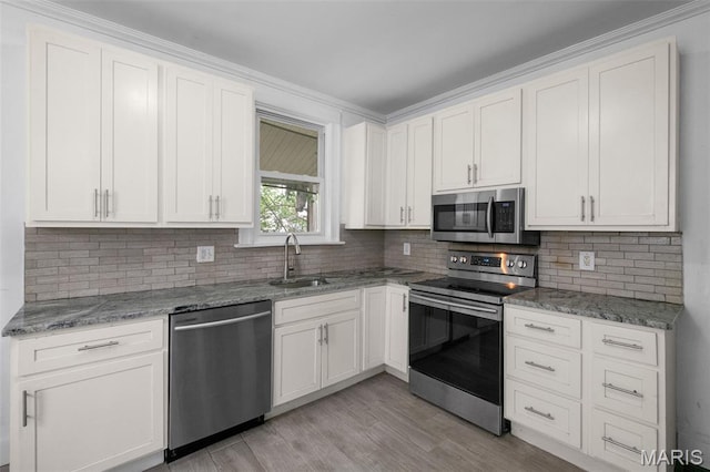 4340 Gannett St, Saint Louis, MO 63116 - kitchen with appliances with stainless steel finishes, tasteful backsplash, light stone countertops, light wood-type flooring, and white cabinetry