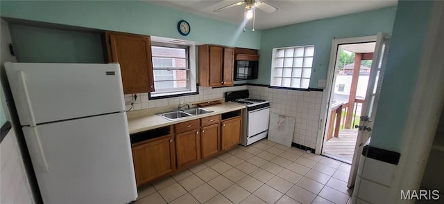 5464 Lindenwood Ave, Saint Louis, MO 63109 - kitchen with white appliances, brown cabinetry, a ceiling fan, healthy amount of natural light, and tile walls