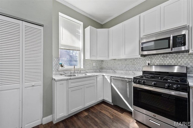 2610 Rutger St, Saint Louis, MO 63104 - kitchen with stainless steel appliances, crown molding, dark wood-style flooring, backsplash, and white cabinetry