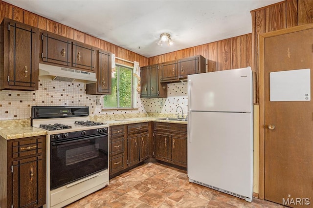 1483 Noche Ct, Fenton, MO 63026 - kitchen with freestanding refrigerator, gas range oven, under cabinet range hood, backsplash, and stone finish flooring