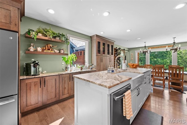 727 Madison Vly, Wildwood, MO 63005 - kitchen featuring stainless steel appliances, light wood finished floors, light stone countertops, recessed lighting, and a center island with sink