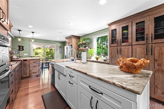 727 Madison Vly, Wildwood, MO 63005 - kitchen featuring stainless steel appliances, recessed lighting, light wood finished floors, decorative light fixtures, and light stone counters