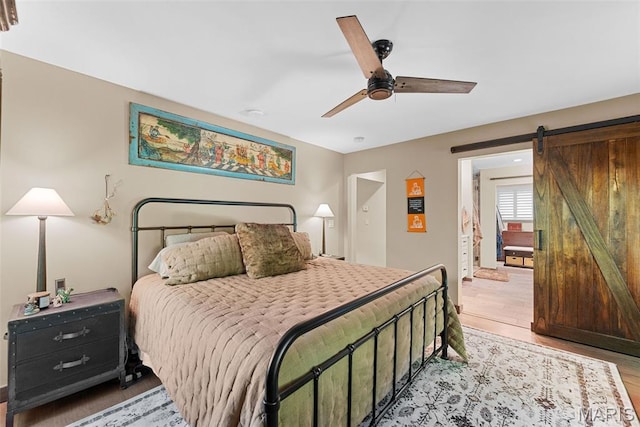 727 Madison Vly, Wildwood, MO 63005 - bedroom with light wood-style flooring, a barn door, and ceiling fan