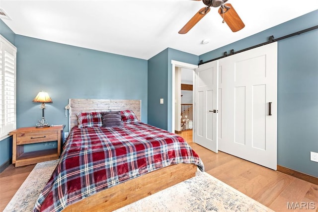 727 Madison Vly, Wildwood, MO 63005 - bedroom featuring a barn door, wood finished floors, and ceiling fan