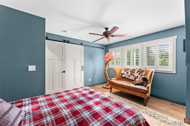 727 Madison Vly, Wildwood, MO 63005 - bedroom featuring a barn door, wood finished floors, and ceiling fan