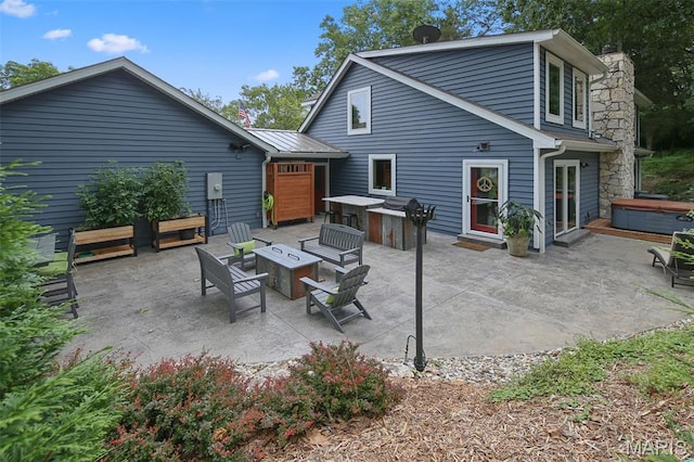 727 Madison Vly, Wildwood, MO 63005 - back of house featuring a hot tub, a fire pit, a patio area, and a chimney