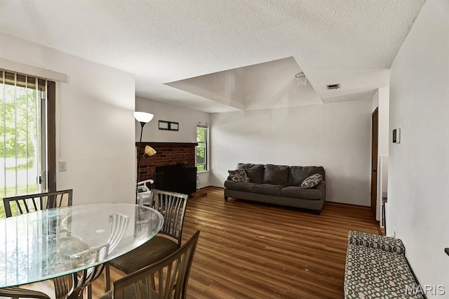 3722 Candlewyck Club Dr D, Unit D, MO 63034 - dining area featuring wood finished floors, a textured ceiling, and a fireplace