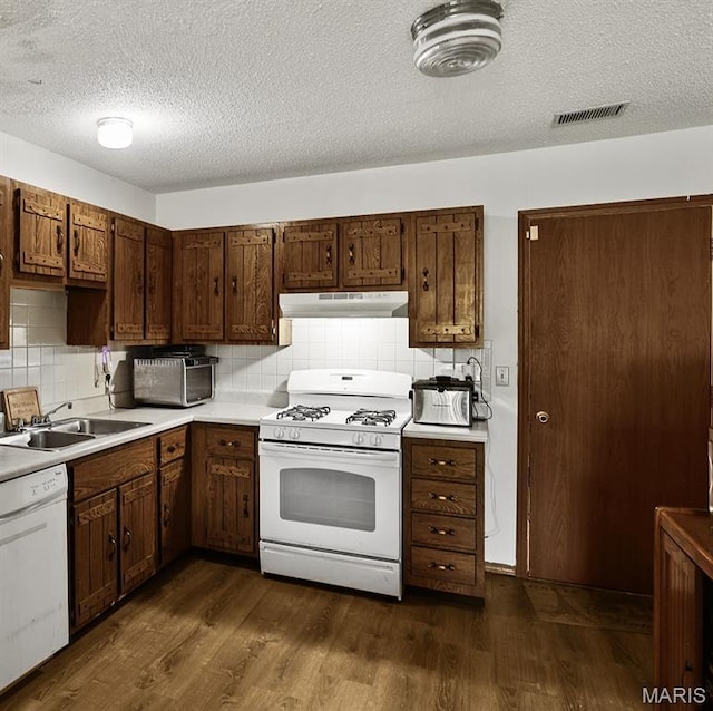 3722 Candlewyck Club Dr D, Unit D, MO 63034 - kitchen with white appliances, under cabinet range hood, a textured ceiling, dark wood finished floors, and backsplash