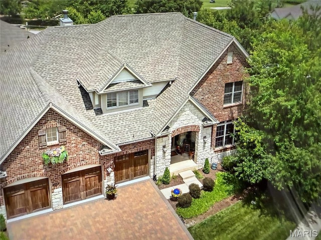 259 Meadowbrook Country Club Est, Ballwin, MO 63011 - view of front facade with roof with shingles, stone siding, an attached garage, decorative driveway, and brick siding