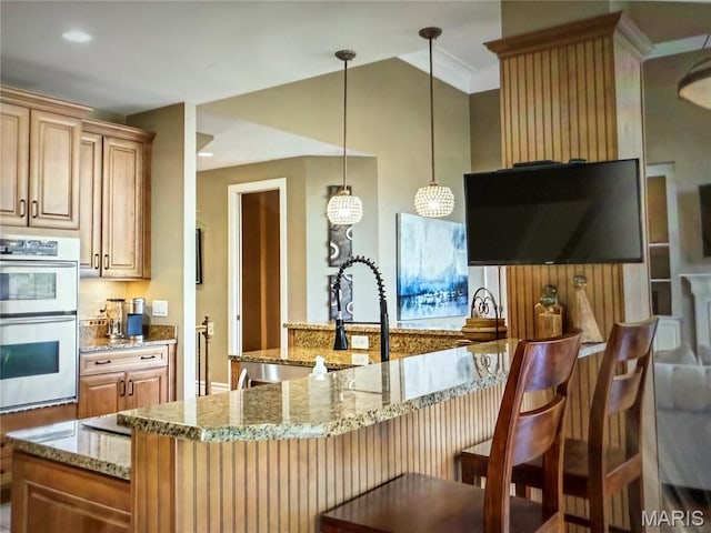 259 Meadowbrook Country Club Est, Ballwin, MO 63011 - kitchen with stainless steel double oven, light stone countertops, a breakfast bar, decorative light fixtures, and ornamental molding