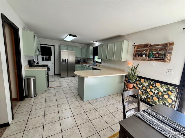 826 Birdie Ln, Jackson, MO 63755 - kitchen featuring stainless steel fridge with ice dispenser, a peninsula, green cabinetry, light countertops, and light tile patterned flooring
