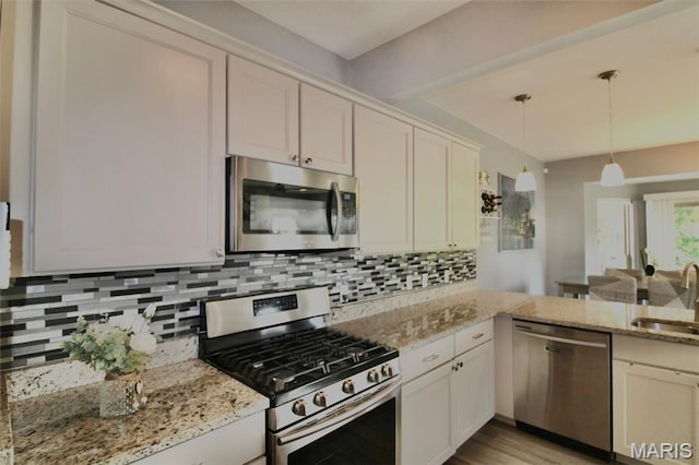 1001 Windsor Crest Ct, Cottleville, MO 63376 - kitchen with appliances with stainless steel finishes, decorative backsplash, decorative light fixtures, and light stone counters