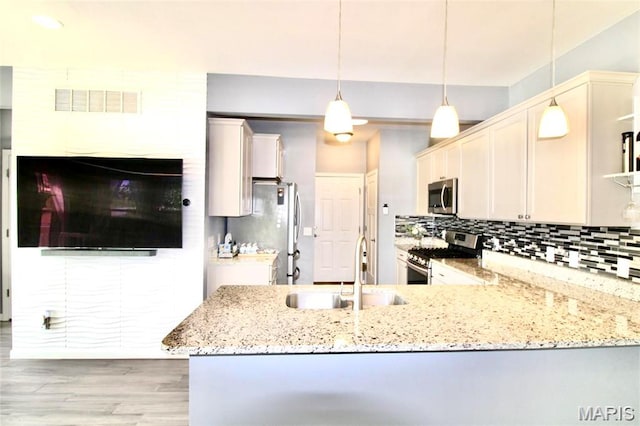1001 Windsor Crest Ct, Cottleville, MO 63376 - kitchen featuring stainless steel appliances, light wood-style floors, light stone countertops, and decorative backsplash