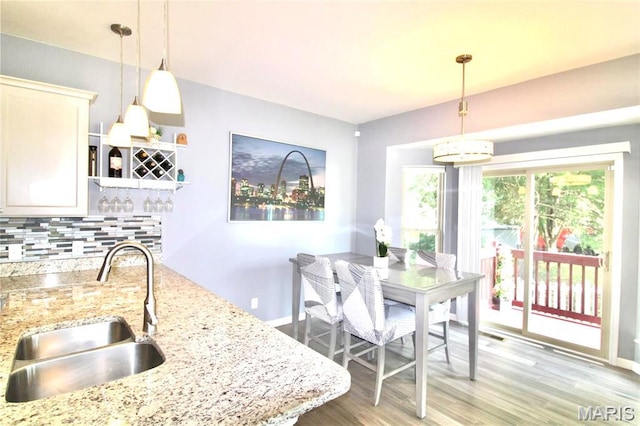 1001 Windsor Crest Ct, Cottleville, MO 63376 - kitchen featuring decorative backsplash, light wood-type flooring, decorative light fixtures, light stone counters, and open shelves
