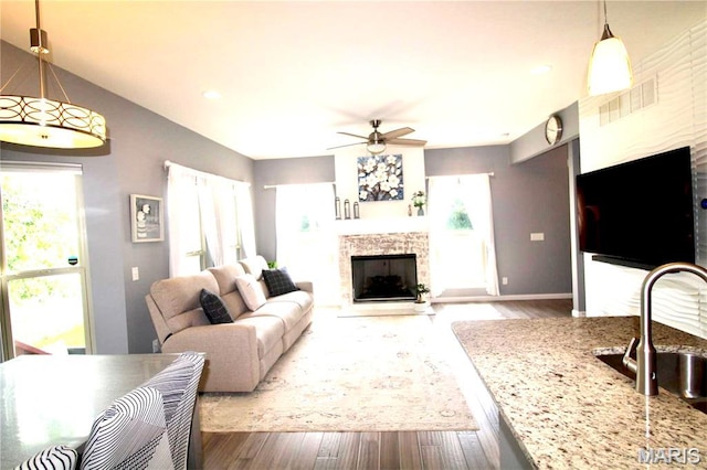 1001 Windsor Crest Ct, Cottleville, MO 63376 - living area with a fireplace, healthy amount of natural light, a ceiling fan, wood finished floors, and recessed lighting
