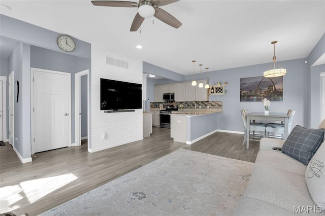 1001 Windsor Crest Ct, Cottleville, MO 63376 - living area with wood finished floors, a ceiling fan, and recessed lighting