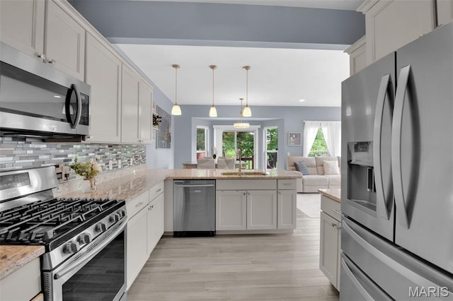 1001 Windsor Crest Ct, Cottleville, MO 63376 - kitchen with stainless steel appliances, light wood-type flooring, decorative backsplash, a peninsula, and light stone countertops