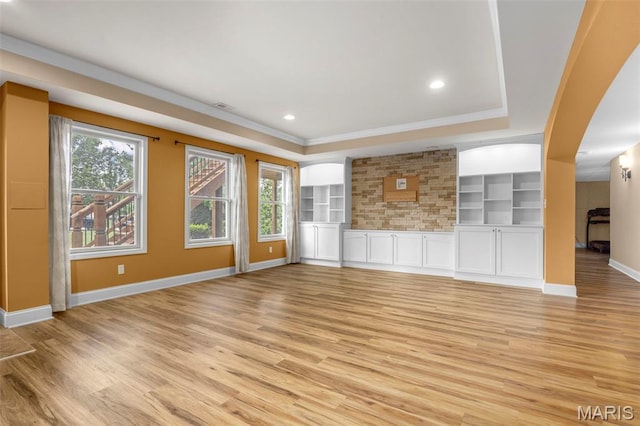 105 Cypress Meadows Dr, Wentzville, MO 63385 - unfurnished living room featuring a tray ceiling, light wood-style flooring, arched walkways, ornamental molding, and recessed lighting
