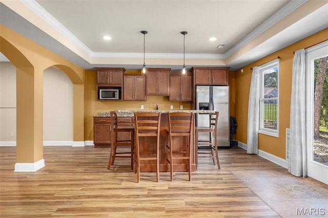 105 Cypress Meadows Dr, Wentzville, MO 63385 - kitchen featuring stainless steel appliances, arched walkways, light wood-style flooring, a breakfast bar, and crown molding