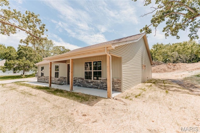 501 W 2nd, Dixon, MO 65459 - view of property exterior featuring stone siding and a patio area