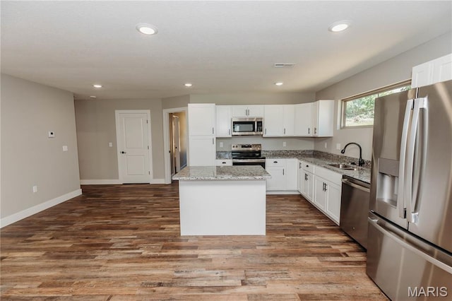 501 W 2nd, Dixon, MO 65459 - kitchen featuring appliances with stainless steel finishes, a center island, light stone counters, white cabinetry, and recessed lighting