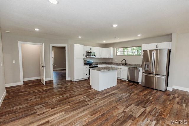 501 W 2nd, Dixon, MO 65459 - kitchen featuring stainless steel appliances, dark wood-style floors, white cabinetry, a kitchen island, and light stone counters