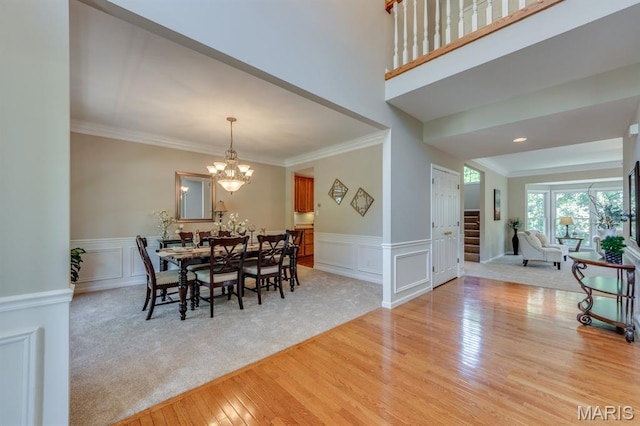 1515 Dietrich Glen Dr, Ballwin, MO 63021 - dining space featuring light wood-type flooring, stairway, crown molding, a decorative wall, and a chandelier