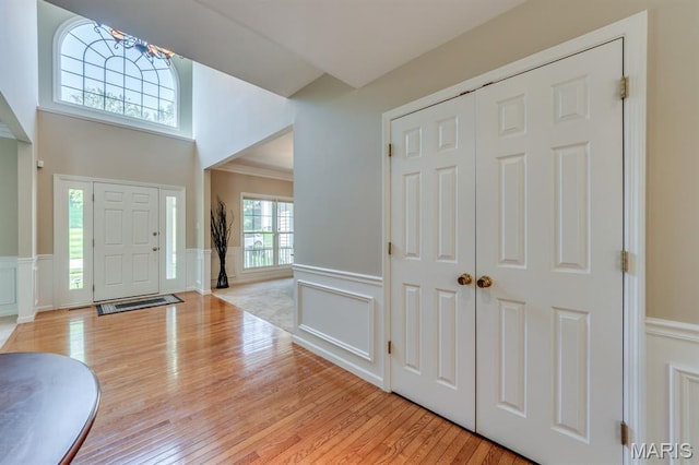 1515 Dietrich Glen Dr, Ballwin, MO 63021 - foyer entrance featuring a decorative wall, a chandelier, wainscoting, light wood finished floors, and crown molding